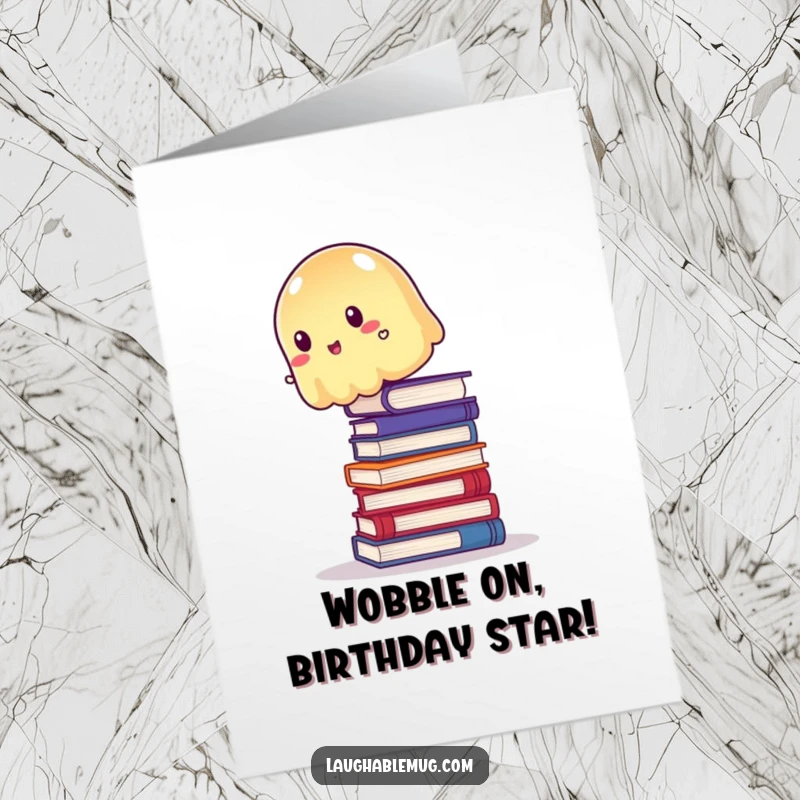 Funny Free Printable Birthday Card: A wobbly, translucent jelly attempting to balance precariously atop a tall stack of colorful books.